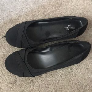A paid of black shoes with short heels.